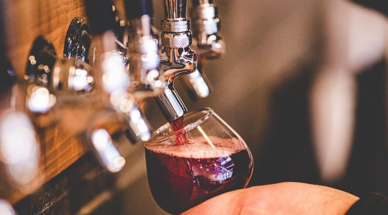 Pouring purple mead from a tap into a glass at Slate Point Meadery Poughkeepsie